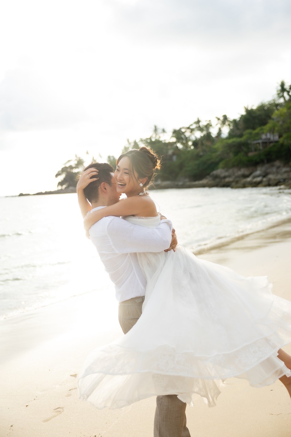 Prima and Kasit embracing on the beach at golden hour